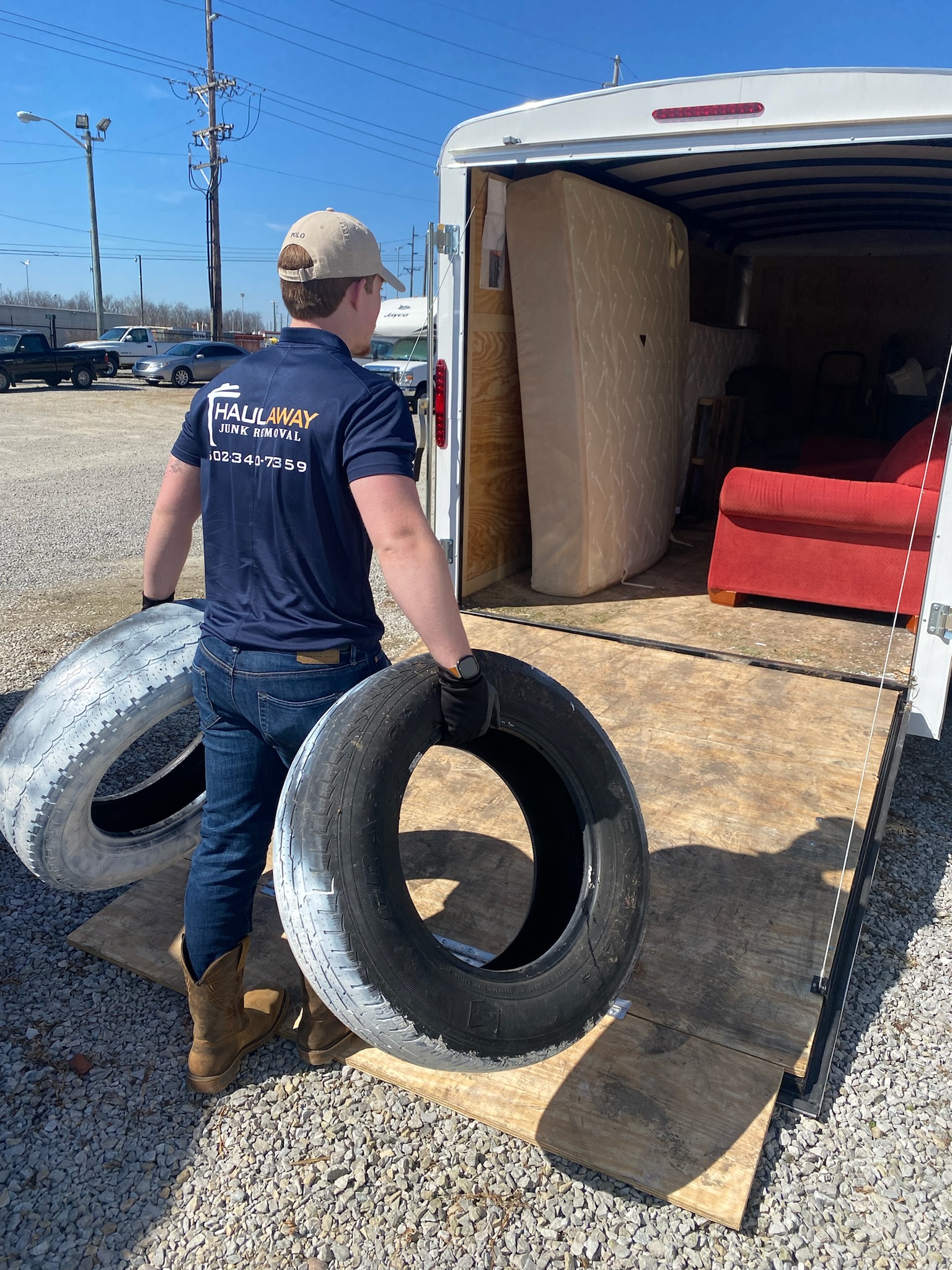 A Haulaway Junk Removal expert hauling garage junk to a trailer